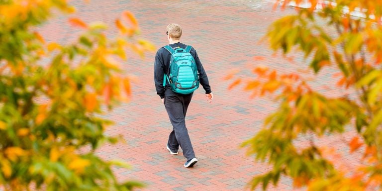 Leaves starting to change color in the crisp fall air frame an ECU student as he makes his way to class near the Sci Tech Building on Tuesday, October, 31, 2017.  (ECU Photo by Rhett Butler)